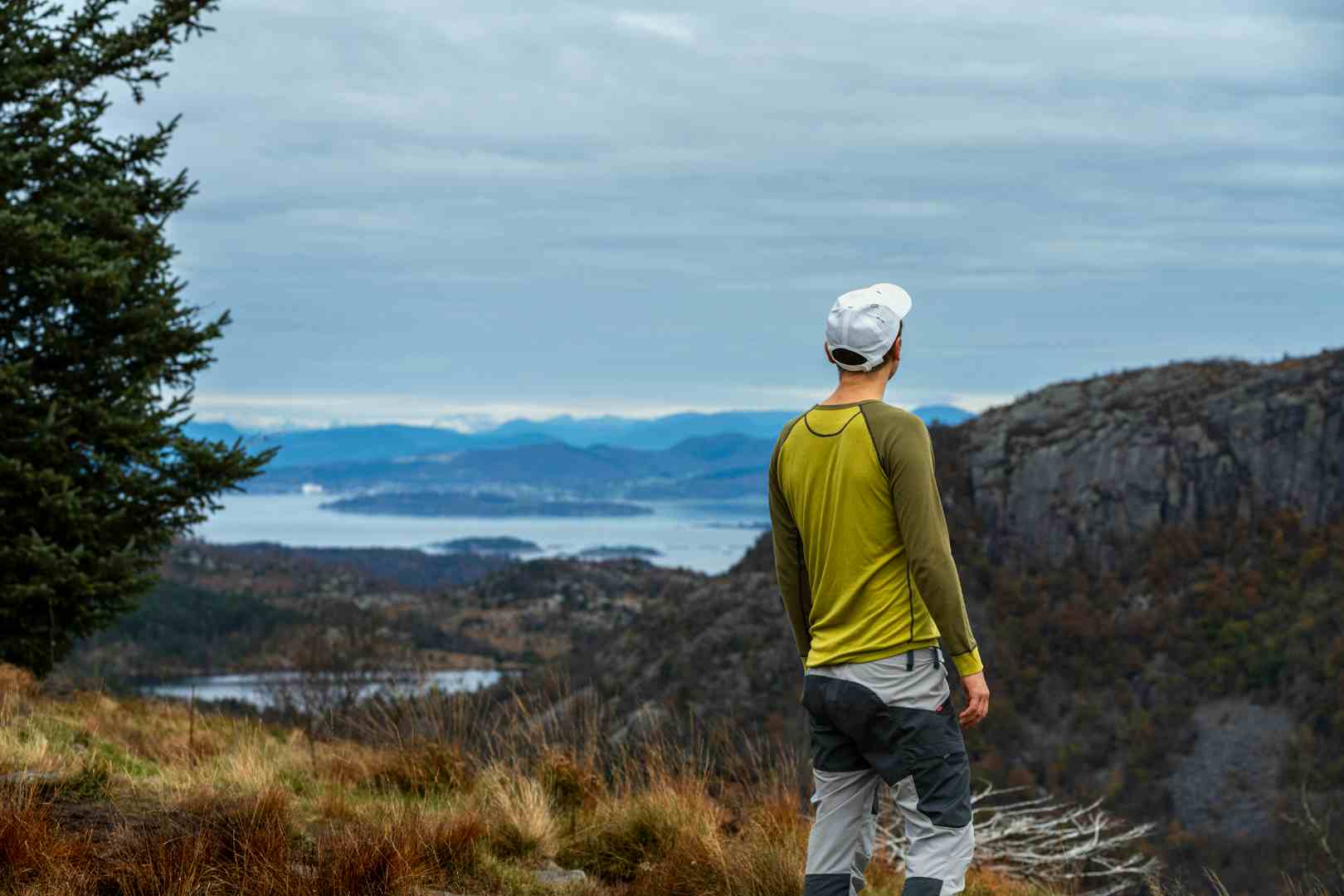 Man watching a waterfall in scenic surroundings in Norway