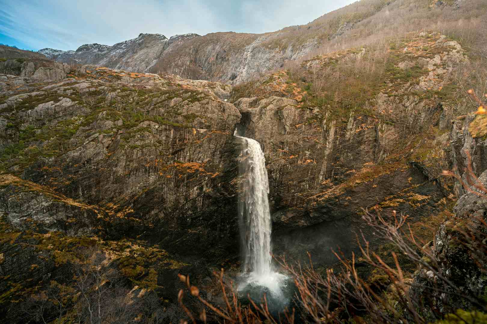 Man watching a waterfall in scenic surroundings in Norway