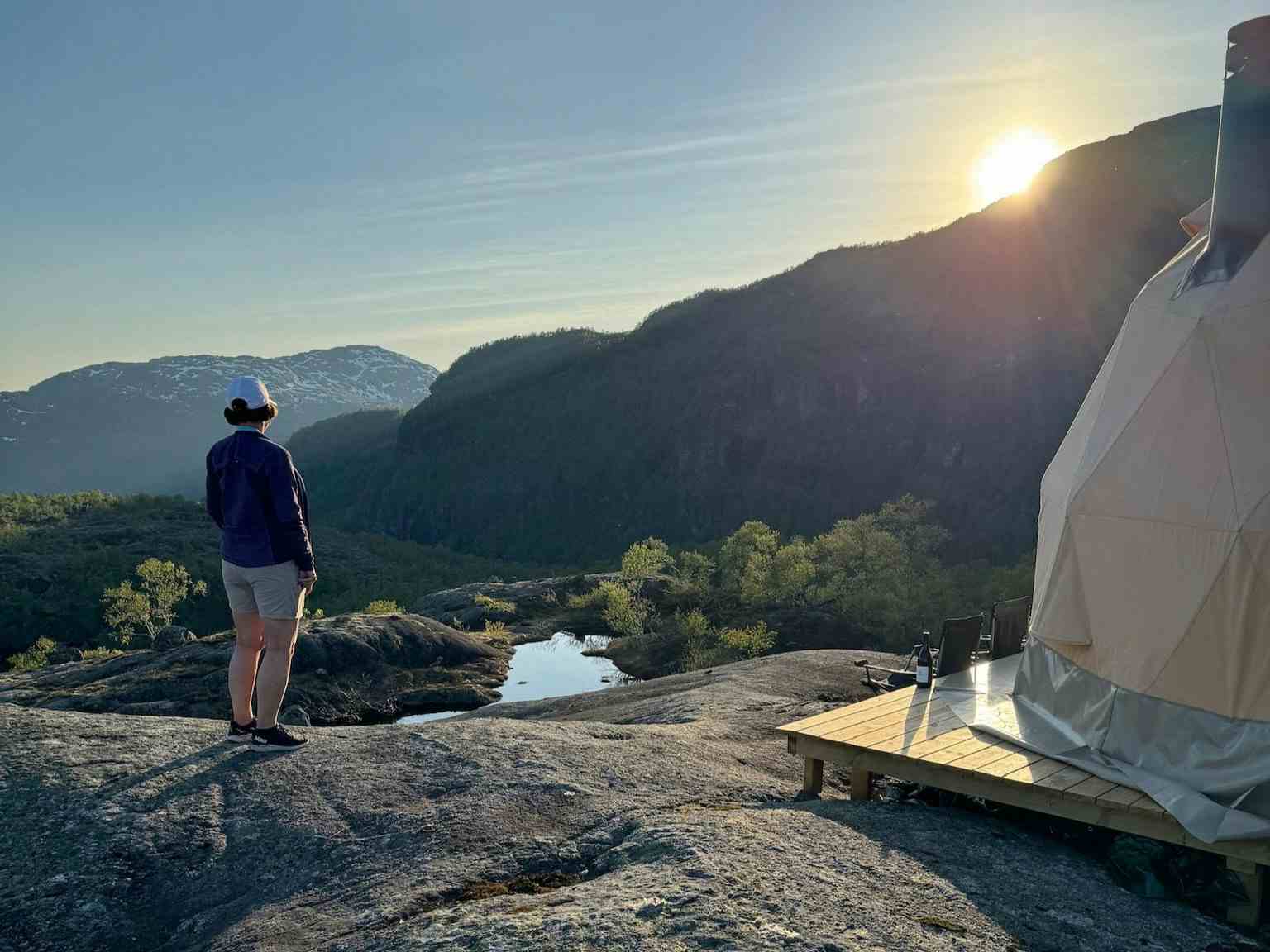 To personer som sitter inne i glamping-teltet og nyter utsikten over Saudafjellet.