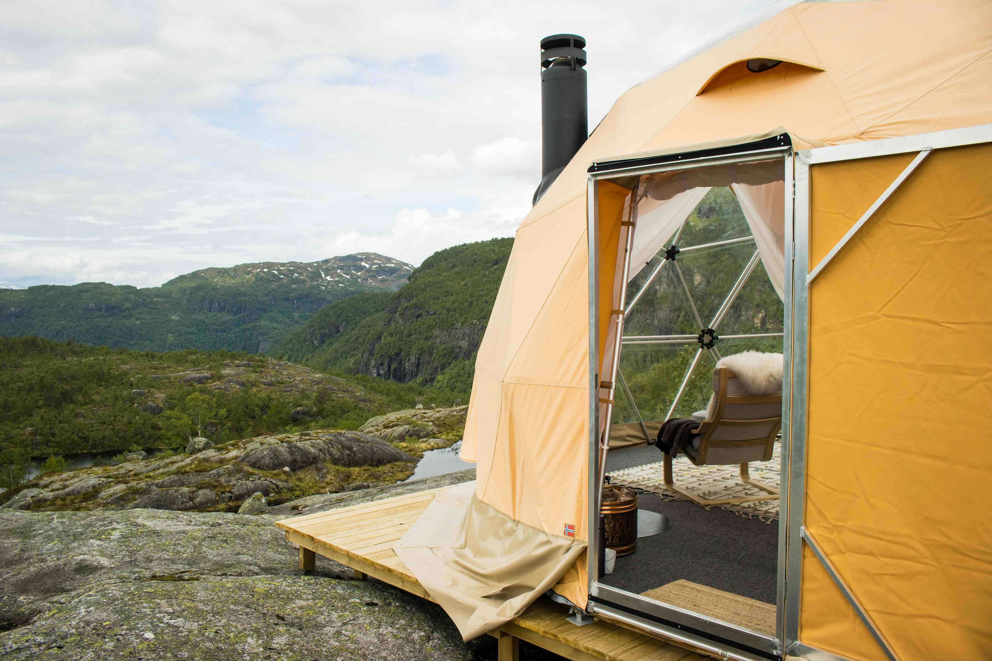 To personer som sitter inne i glamping-teltet og nyter utsikten over Saudafjellet.